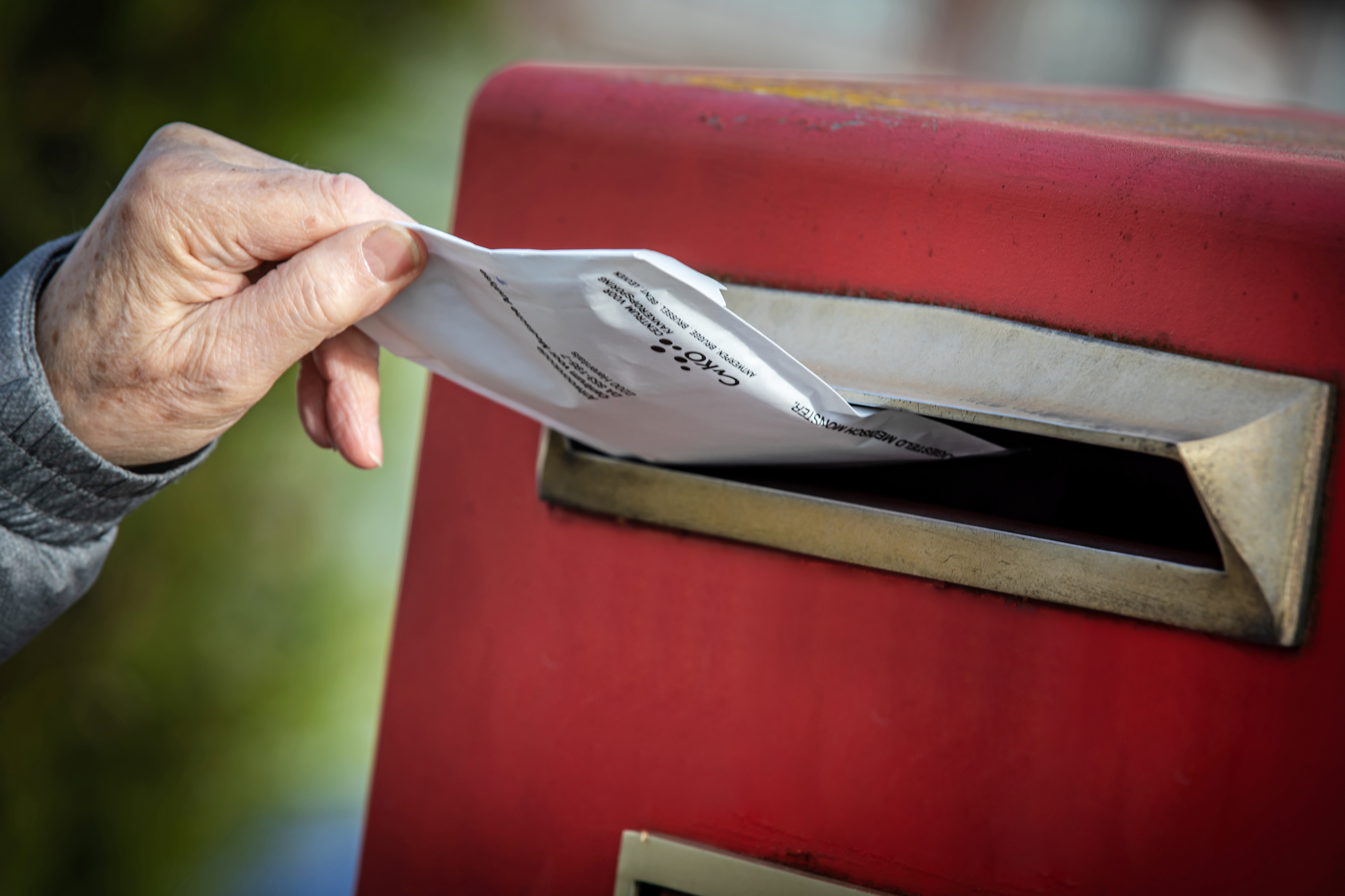 Man post envelop in rode postbus